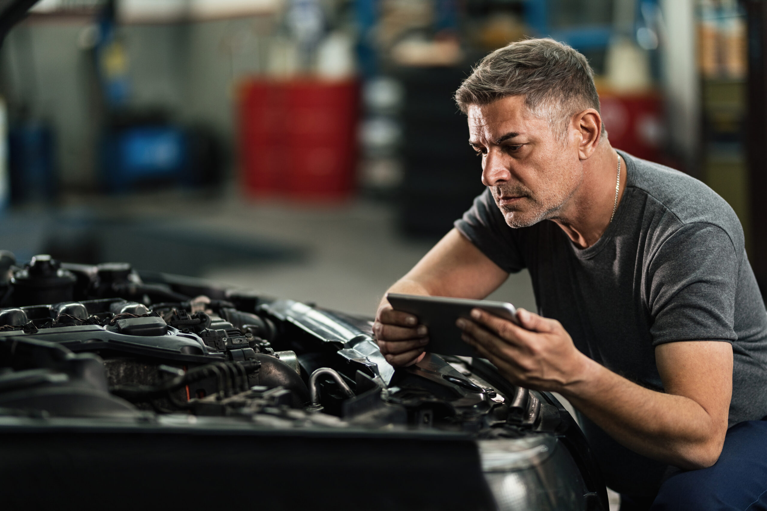 Auto body technician performing a diagnostic scan on a modern vehicle