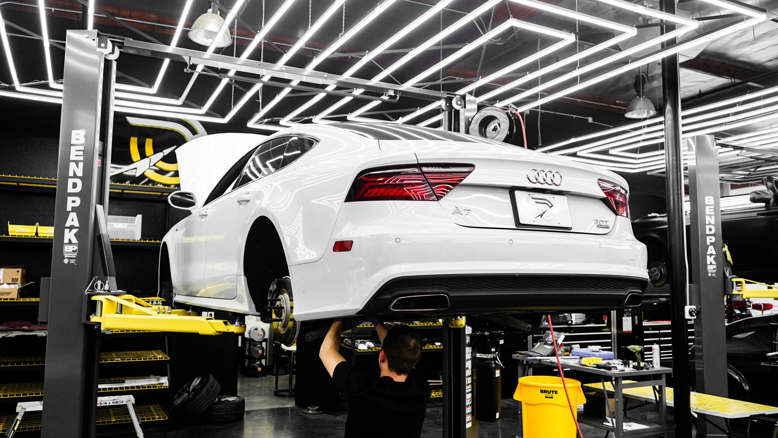 Technician working on an Audi body panel in a collision repair bay